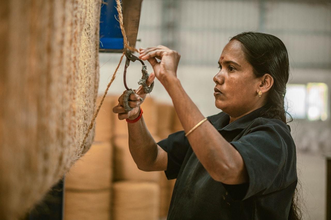 Balterra worker processing coir fiber at the village mill